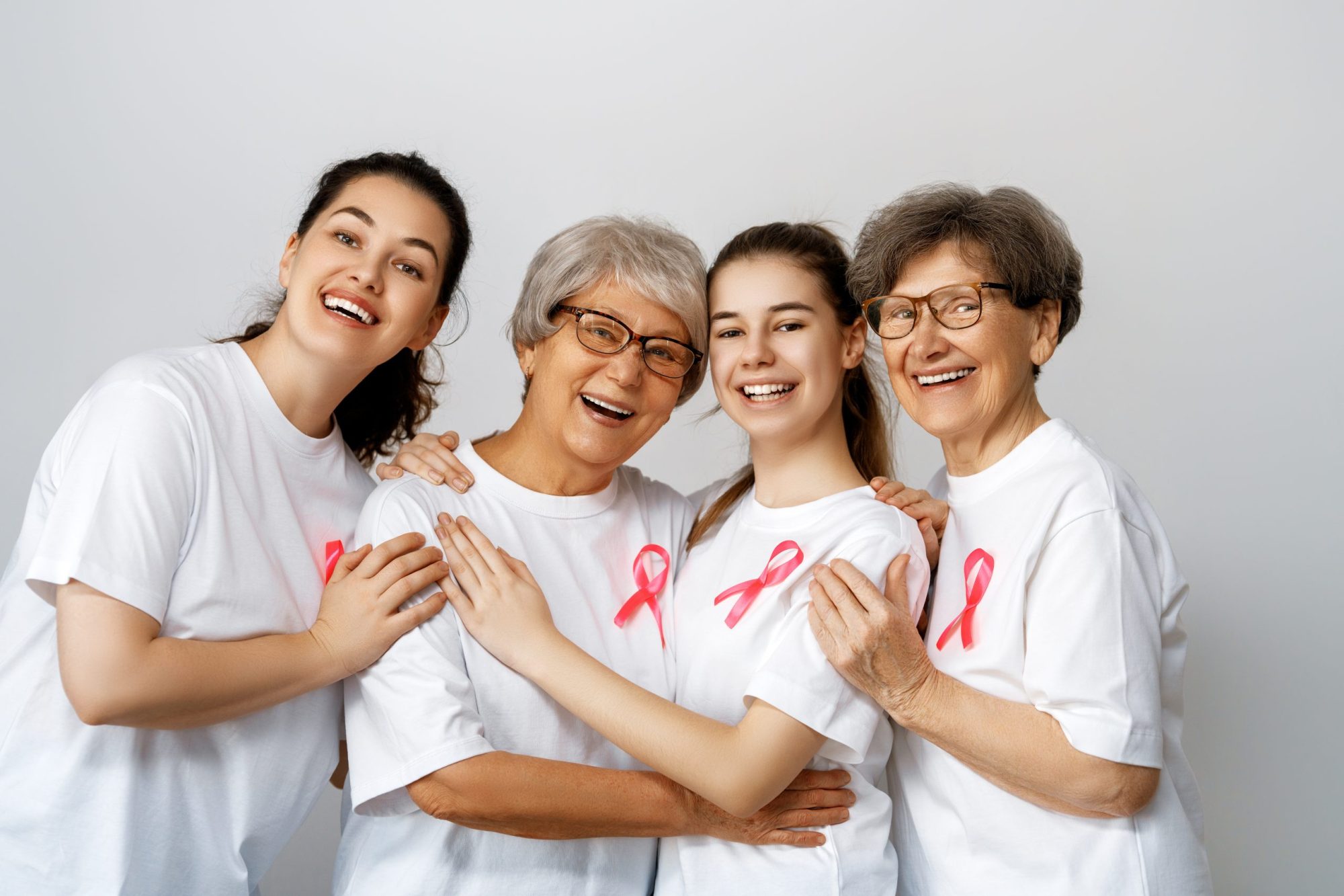 Smiling women with pink satin ribbon symbolizing concept of illness awareness, expressing solidarity and support for cancer patients and survivors. Different generations of people